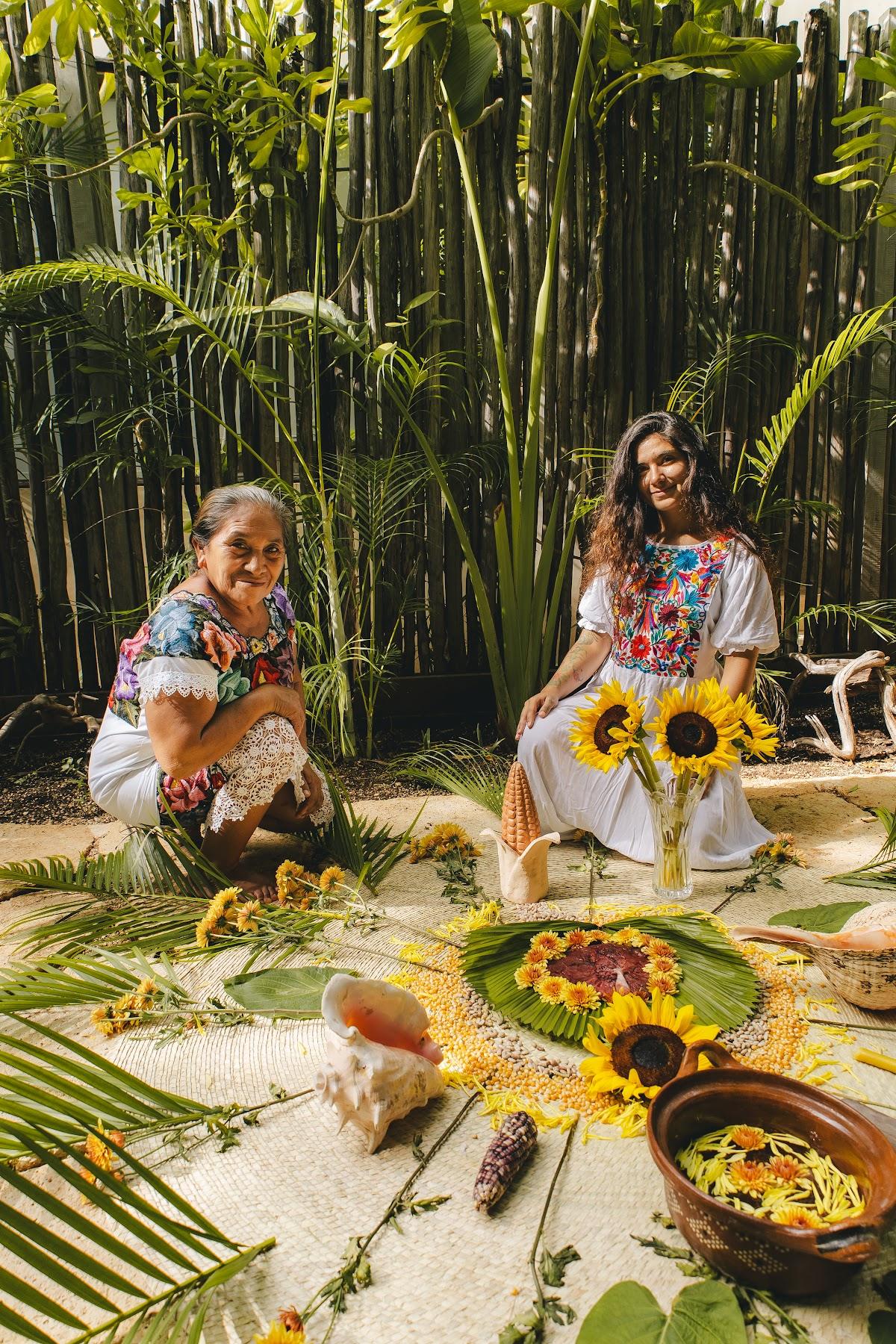 Parteras junto a una ofrenda de flores y hojas de palma / Midwives beside an offering of flowers and palm leaves